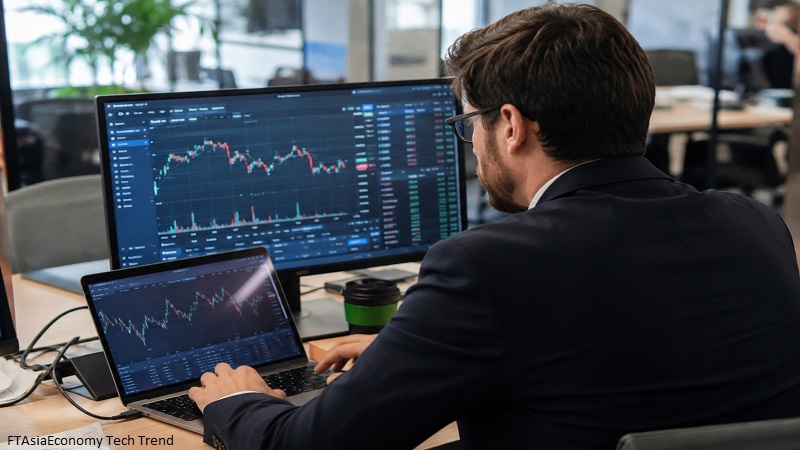 FTAsiaEconomy Tech Trend showing a financial analyst reviewing AI-powered market data and digital technology insights in a modern office.